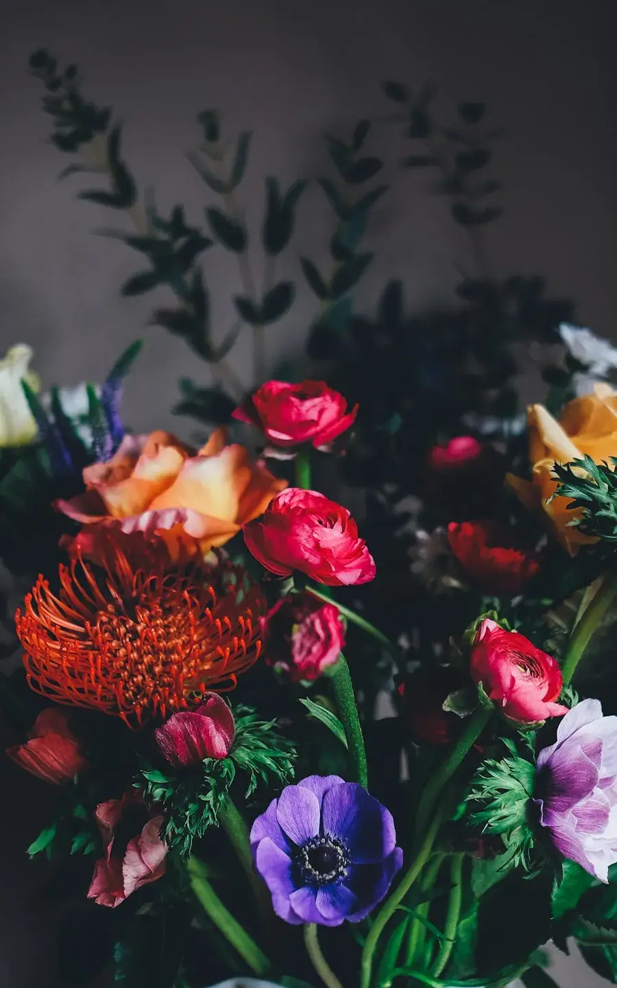 Bouquet de fleurs fraîches tenu à deux mains devant la boutique